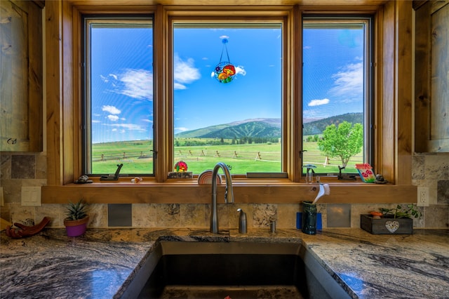 kitchen with a mountain view, stone counters, and plenty of natural light