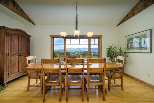 dining space featuring a chandelier, lofted ceiling, light hardwood / wood-style floors, and a mountain view