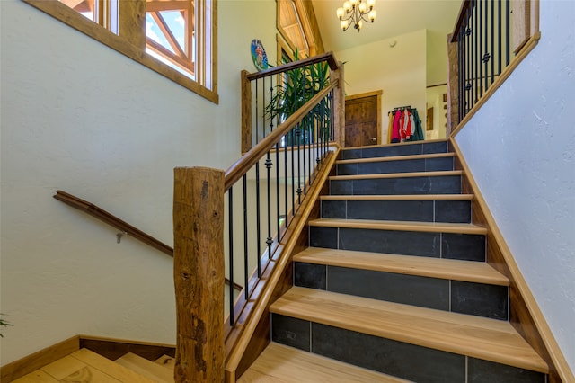 stairway with a chandelier and wood-type flooring