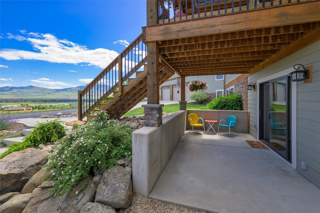 view of patio / terrace featuring a mountain view and a garage