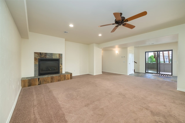 unfurnished living room with carpet floors, ceiling fan, and a tile fireplace