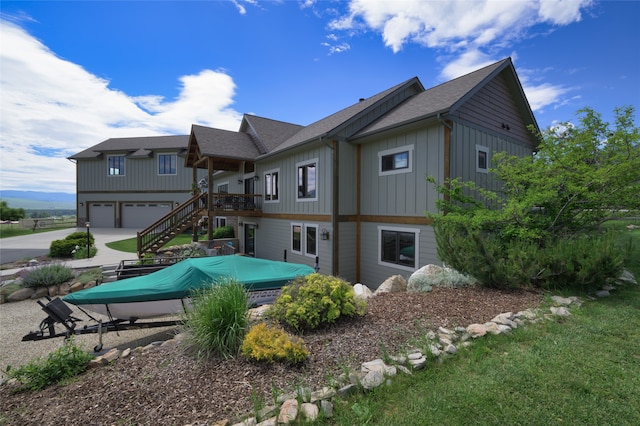 rear view of property with a deck and a garage