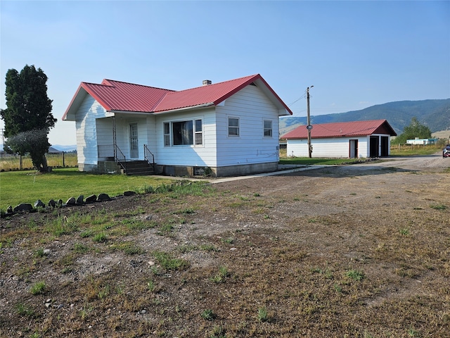 exterior space with a mountain view and a front lawn