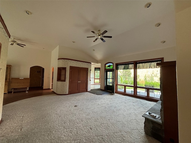 unfurnished living room featuring ceiling fan, carpet floors, and vaulted ceiling