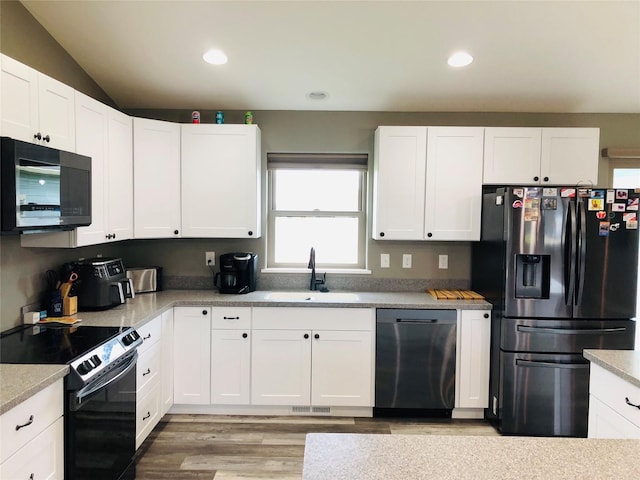 kitchen with stainless steel appliances, white cabinetry, and sink