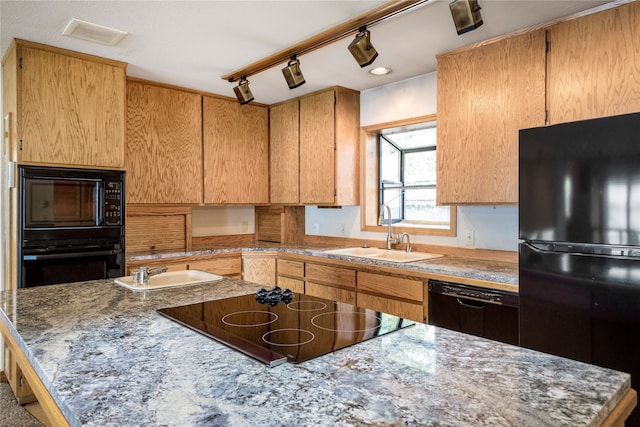 kitchen with sink, a kitchen island, black appliances, and rail lighting