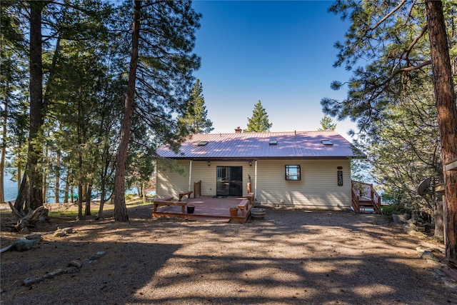 rear view of property featuring a wooden deck