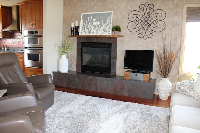 living room featuring hardwood / wood-style flooring and a tiled fireplace