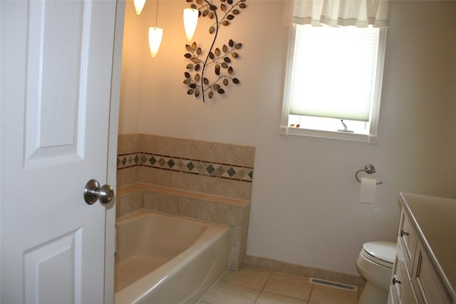 bathroom with tile patterned flooring, vanity, toilet, and a washtub