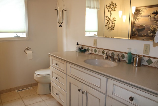 bathroom with tile patterned flooring, plenty of natural light, toilet, and vanity