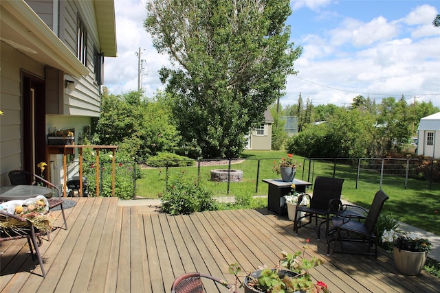 deck featuring an outdoor fire pit and a lawn