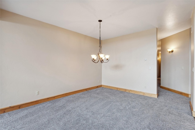 spare room featuring baseboards, carpet, and an inviting chandelier