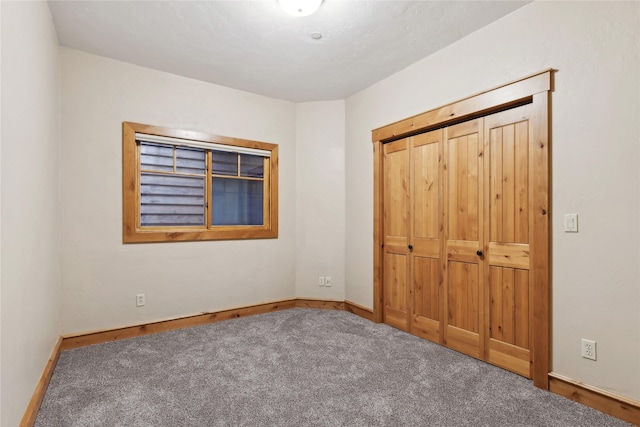 unfurnished bedroom with carpet floors, a closet, and baseboards