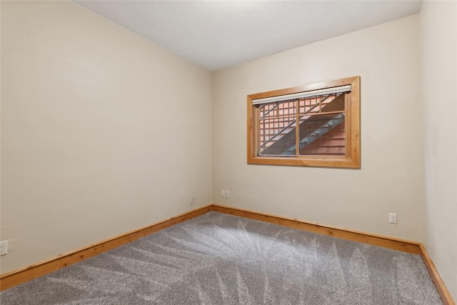 unfurnished room with baseboards and carpet flooring