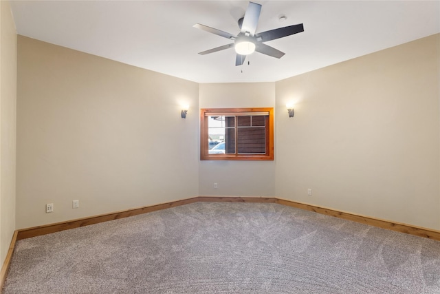 carpeted empty room featuring a ceiling fan and baseboards