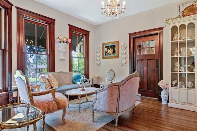 sitting room featuring a chandelier and wood finished floors