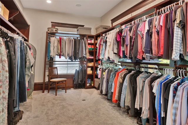 walk in closet featuring light colored carpet