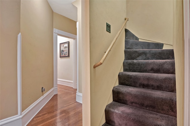 stairs featuring wood finished floors and baseboards