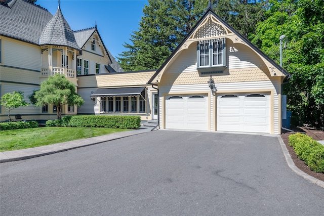 victorian house featuring aphalt driveway and a garage