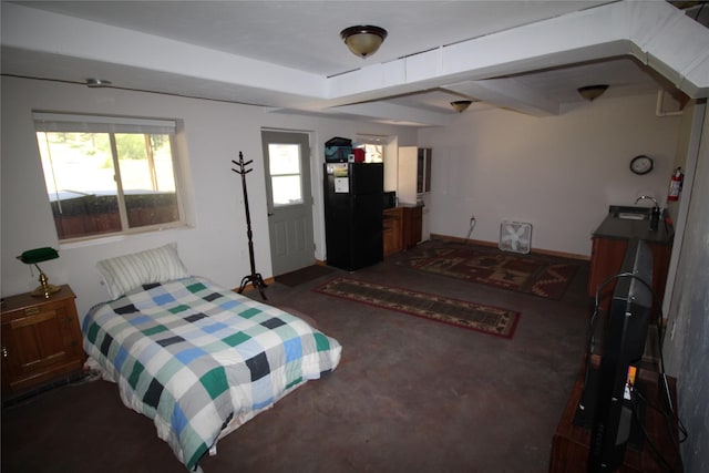 bedroom featuring concrete floors, a sink, and freestanding refrigerator