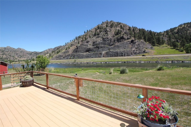 wooden deck with a lawn and a water and mountain view