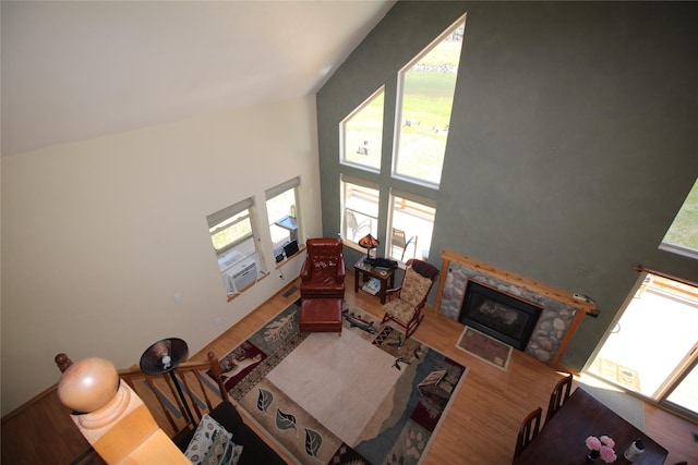 living room with high vaulted ceiling, a fireplace, and wood finished floors