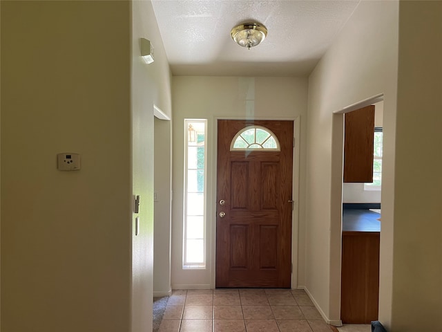 entrance foyer with light tile patterned flooring, a textured ceiling, and plenty of natural light