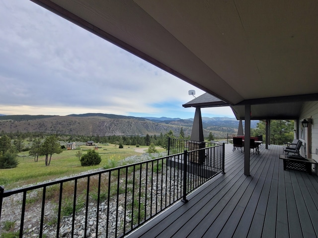 wooden deck with a mountain view and a rural view