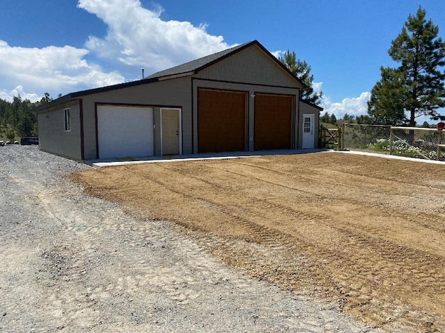 detached garage featuring fence