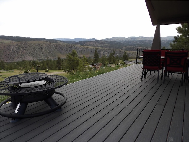 wooden terrace with a mountain view and outdoor dining space