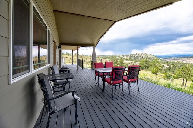 wooden terrace featuring outdoor dining area and a mountain view