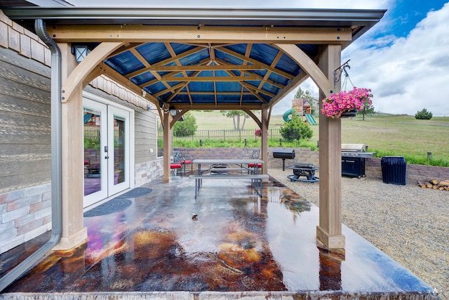 view of patio featuring fence, a gazebo, a fire pit, and french doors