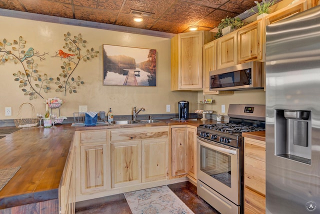 kitchen with visible vents, butcher block counters, light brown cabinets, an ornate ceiling, and stainless steel appliances