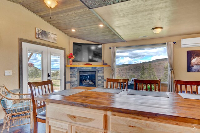dining area with a healthy amount of sunlight, wood ceiling, a wall mounted AC, and a stone fireplace