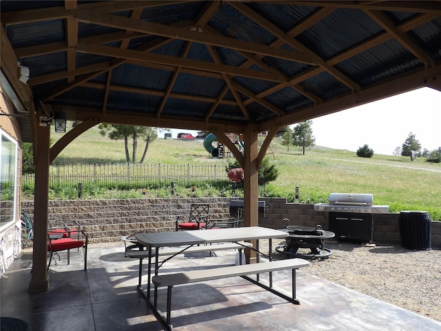 view of patio featuring fence, outdoor dining area, a gazebo, and area for grilling