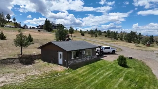 exterior space with dirt driveway and a yard