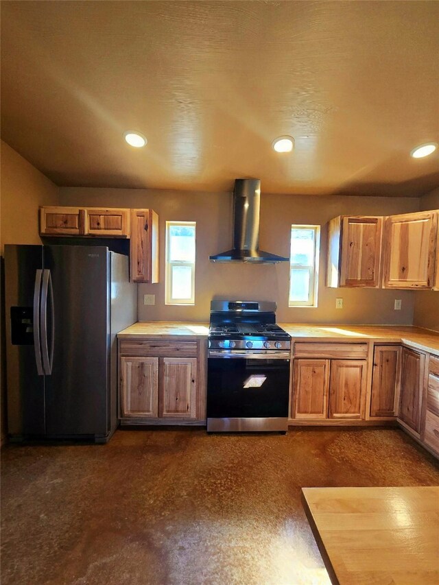 kitchen featuring wall chimney range hood, appliances with stainless steel finishes, a healthy amount of sunlight, and light countertops