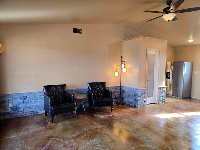 living area with ceiling fan, concrete floors, visible vents, and lofted ceiling
