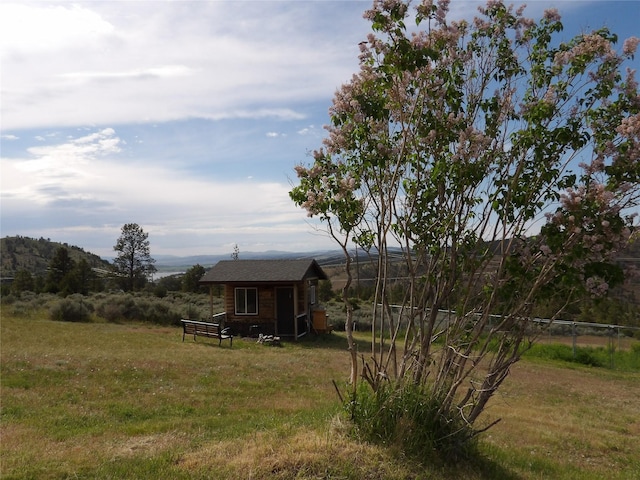 view of yard featuring fence and an outbuilding