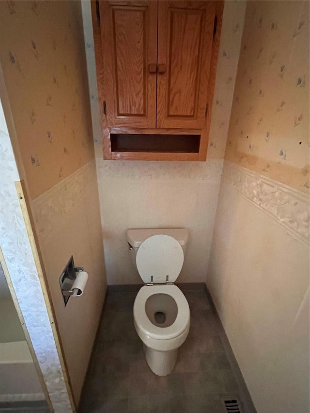 bathroom with tile patterned floors, tile walls, and toilet