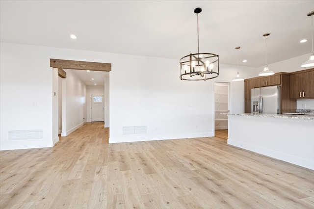 interior space with light wood-type flooring and an inviting chandelier