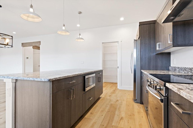 5468 Fireweed Loop, Helena, MT 59602 - kitchen with stainless steel appliances, exhaust hood, a kitchen island, light wood-style flooring, and dark brown cabinets