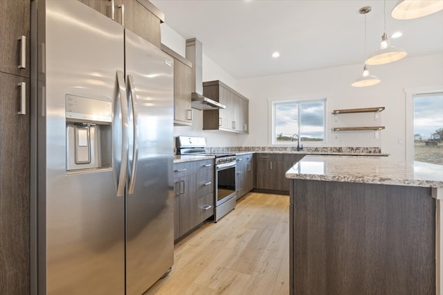 kitchen featuring decorative light fixtures, a healthy amount of sunlight, stainless steel appliances, and light hardwood / wood-style flooring