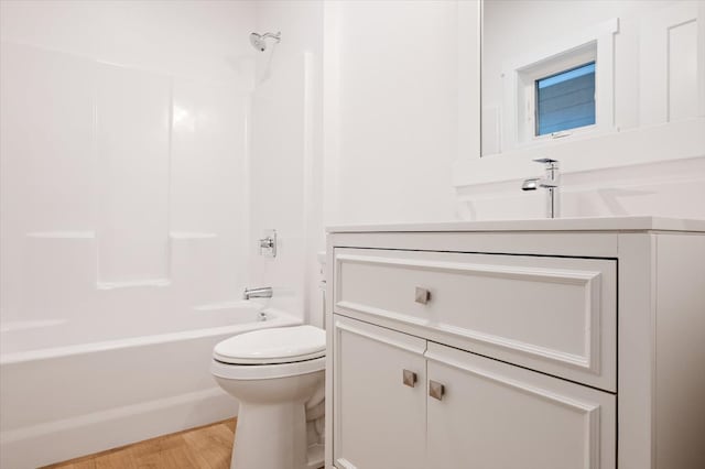 full bathroom with vanity, hardwood / wood-style flooring, toilet, and tub / shower combination