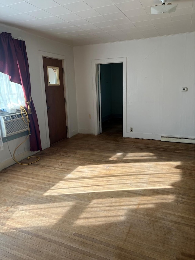 interior space with ceiling fan, cooling unit, light wood-type flooring, and baseboard heating