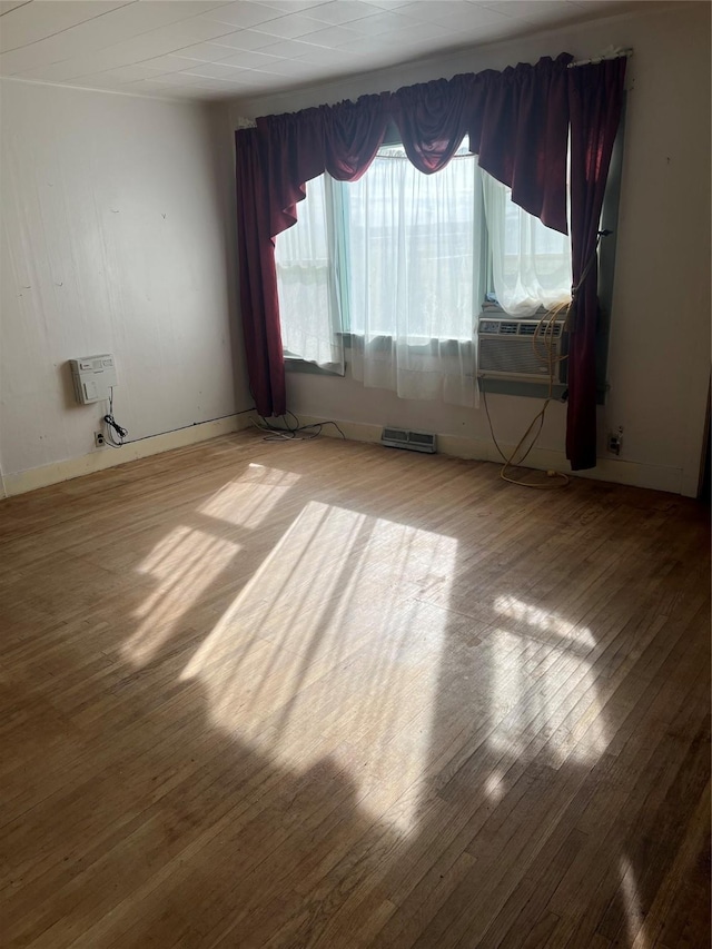 spare room featuring heating unit and hardwood / wood-style flooring