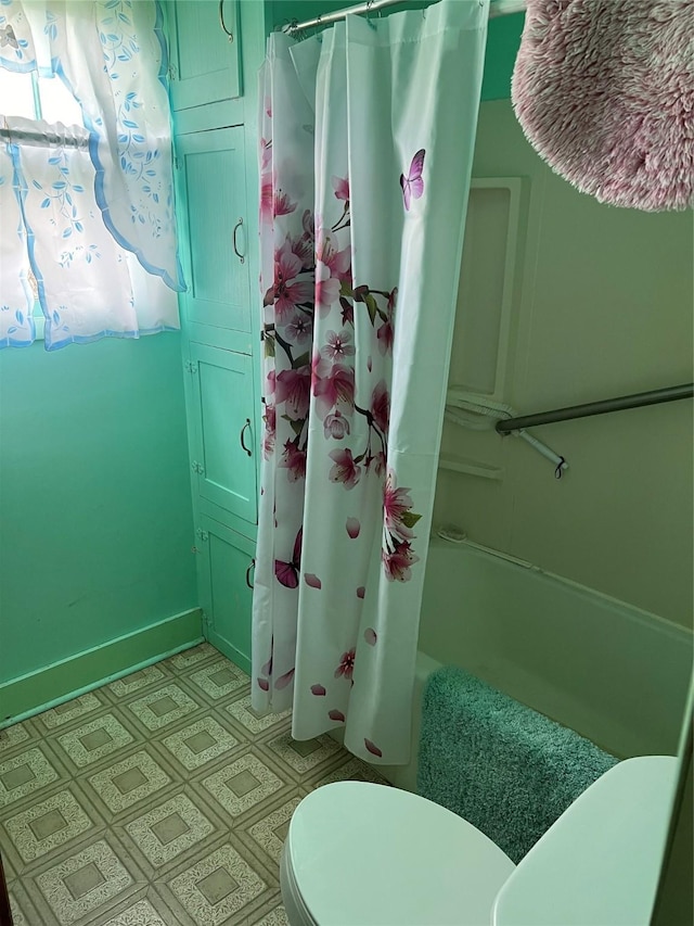 bathroom with shower / bath combo with shower curtain and toilet