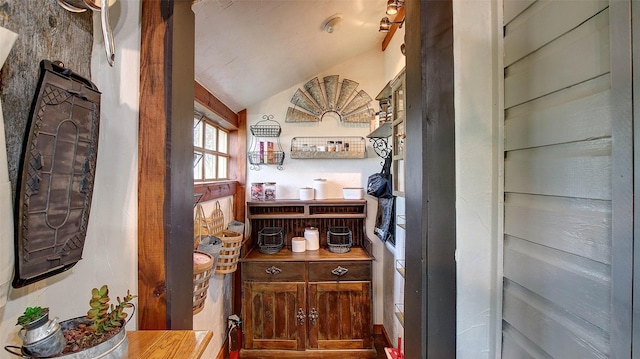 bar featuring wood counters and vaulted ceiling