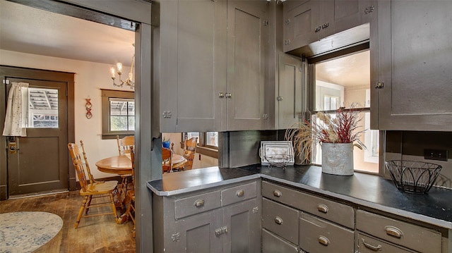 kitchen featuring hardwood / wood-style flooring, gray cabinets, and a notable chandelier