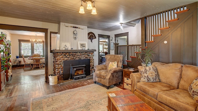 living room featuring wood ceiling, a fireplace, hardwood / wood-style floors, and a notable chandelier